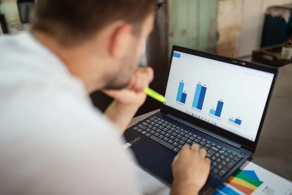 Illustrative photo of a person reviewing bar-chart data on a laptop, representing the kind of structural-signal review behind each audit
